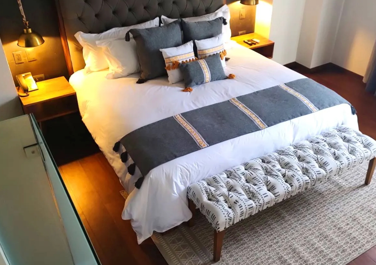 A bedroom with a king size bed and a bench