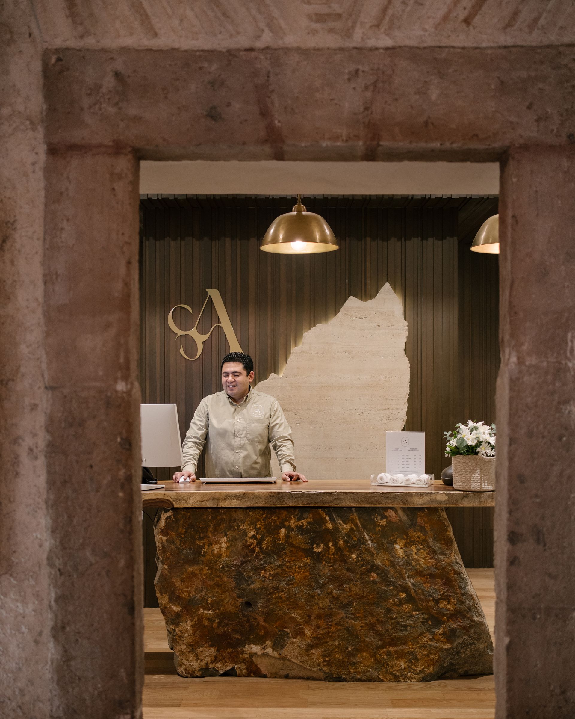 Un hombre está de pie ante un mostrador en el vestíbulo de un hotel.