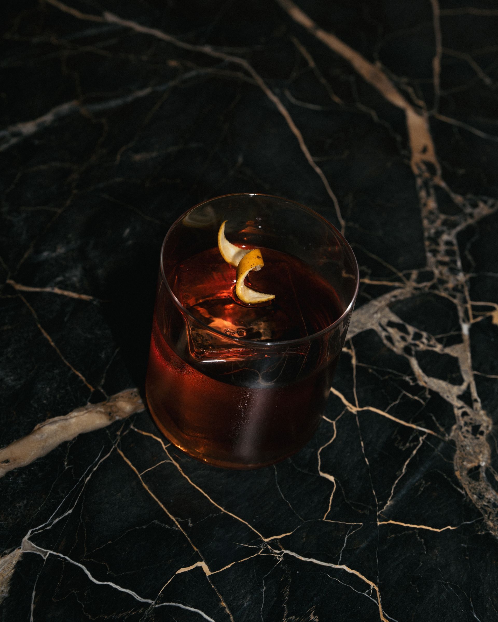 Un primer plano de un vaso de whisky sobre una mesa de mármol.