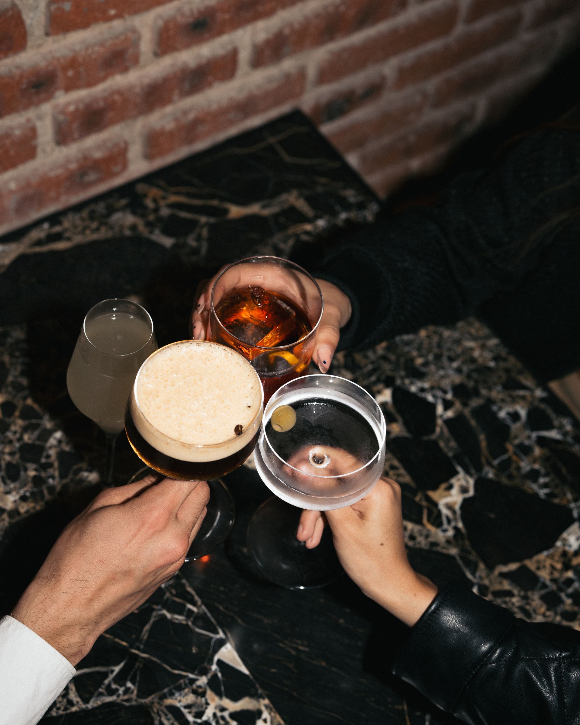 Un grupo de personas está brindando con bebidas en una mesa.