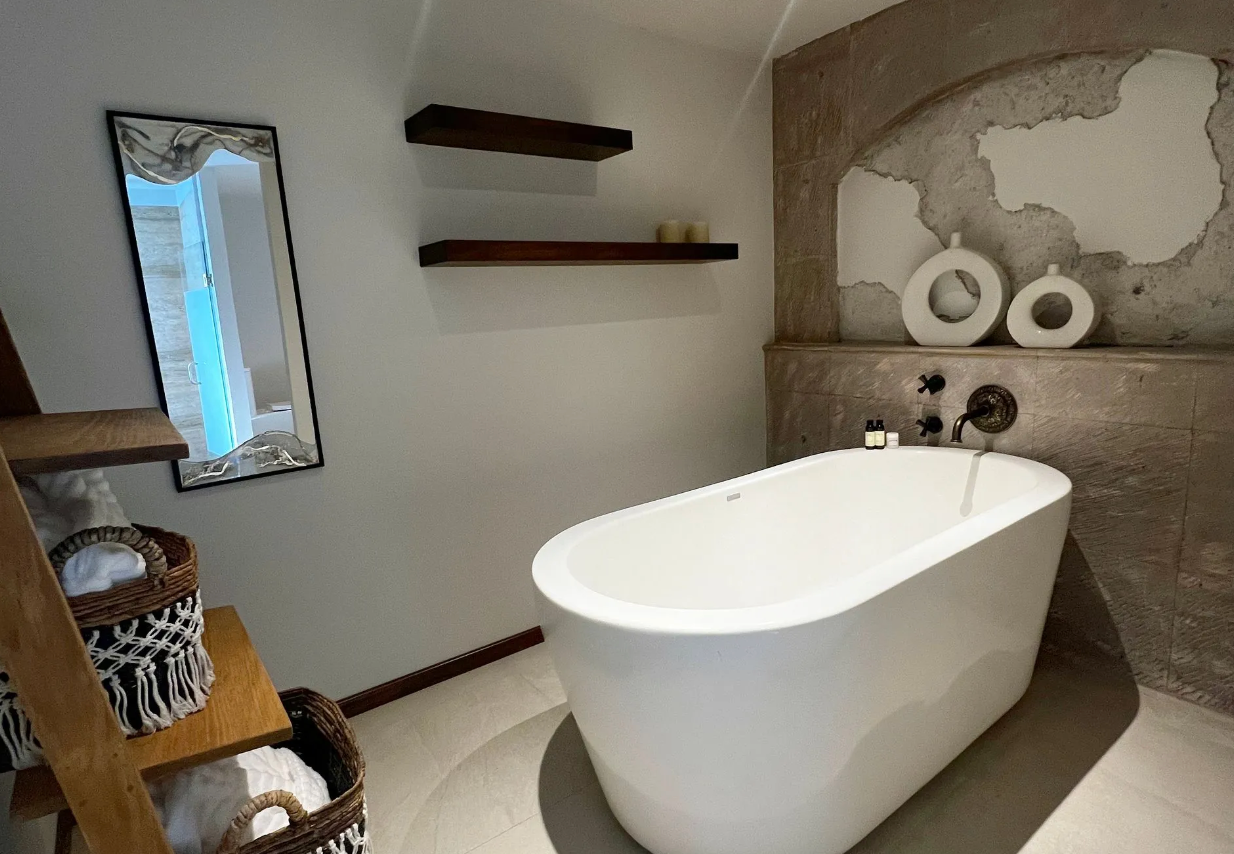A bathroom with a bathtub and a mirror.