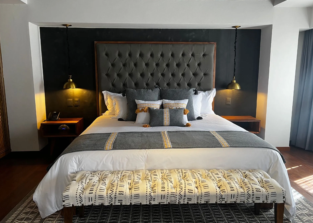 A bedroom with a bed and a bench in front of it