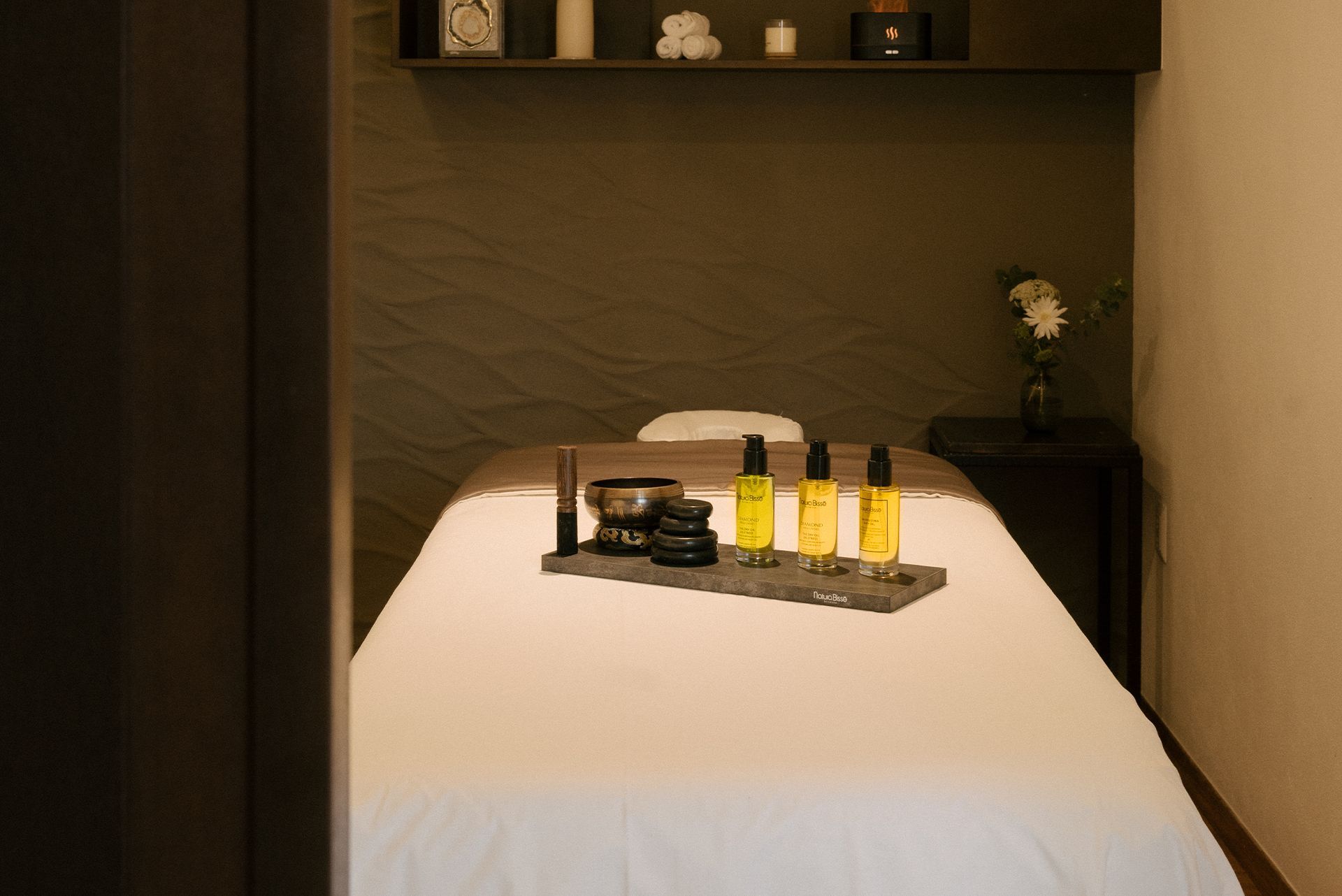 A massage table in a spa with bottles of cosmetics on it.