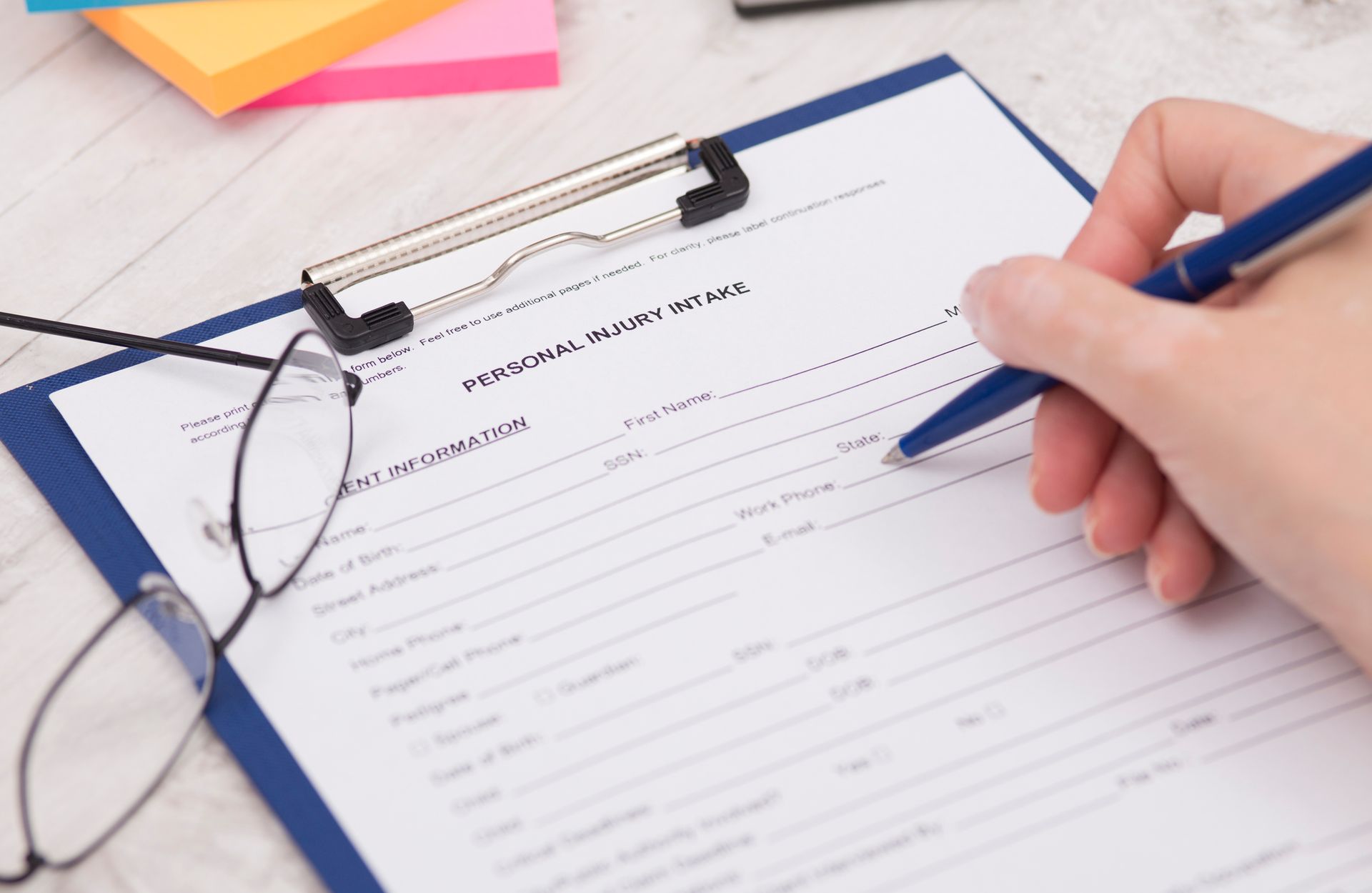 Hand holding pen over clipboard, Robert L. Kelley Attorney at Law, Injury Legal Services Oxnard C