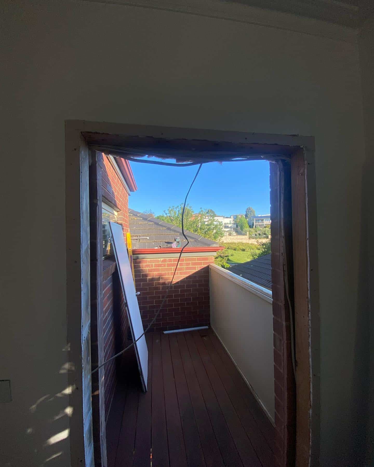 A Doorway Leading to A Balcony with A Brick Building in The Background — Flintoff Constructions in Charlemont, VIC