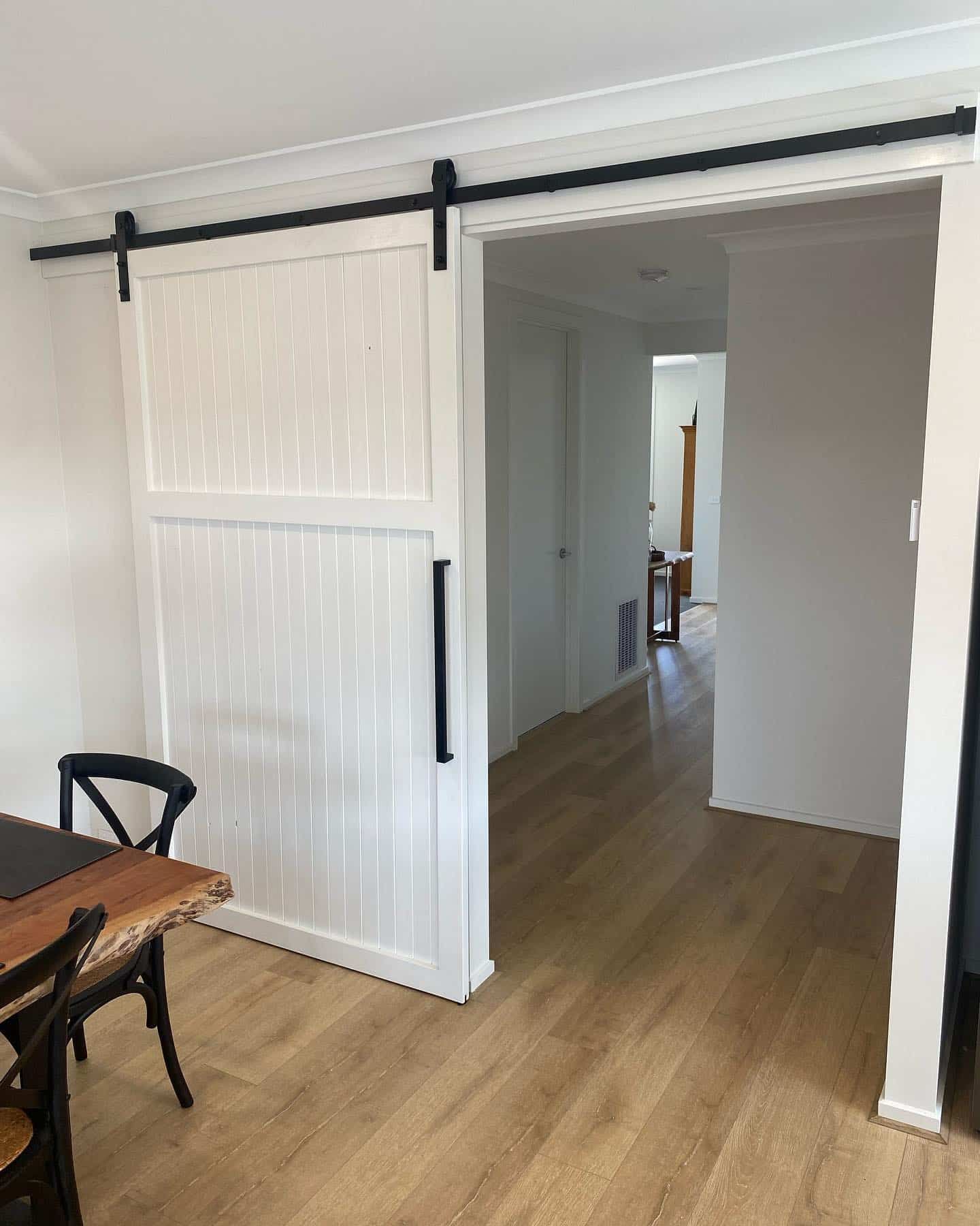 A Dining Room with A Table and Chairs and A Sliding Barn Door — Flintoff Constructions in Charlemont, VIC