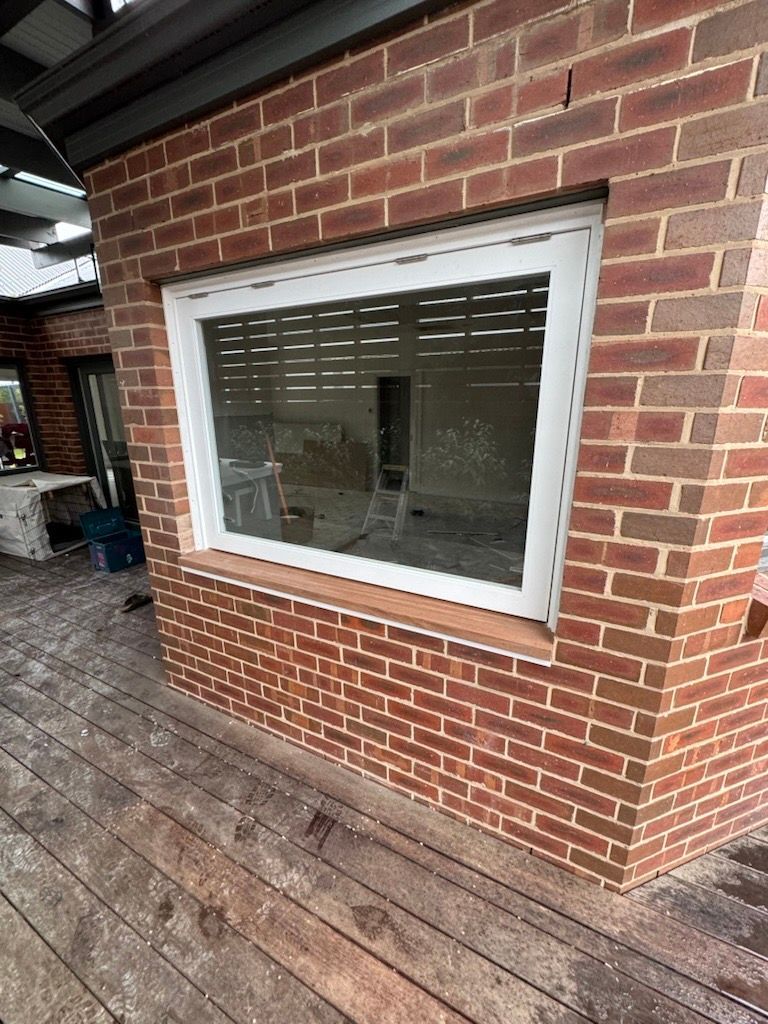 A Man Is Fixing a Window with A Hammer and A Screwdriver — Flintoff Constructions in Charlemont, VIC