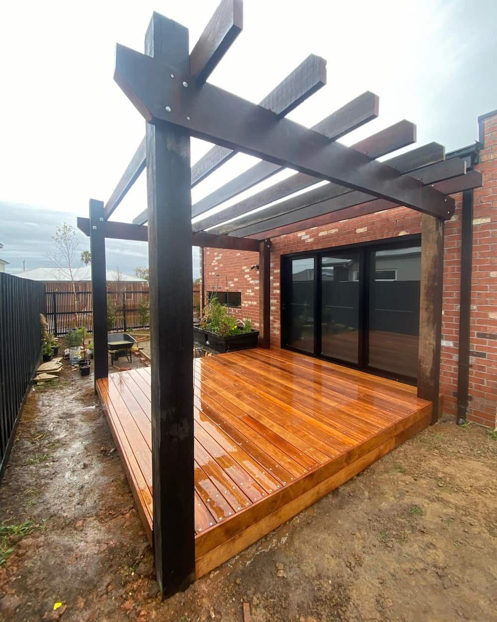 Wooden Deck with A Pergola Over It in Front of A Brick House — Flintoff Constructions in Charlemont, VIC