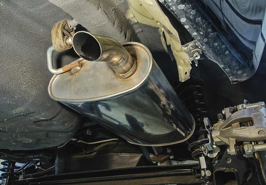 An exhaust muffler attached to the underside of a vehicle.