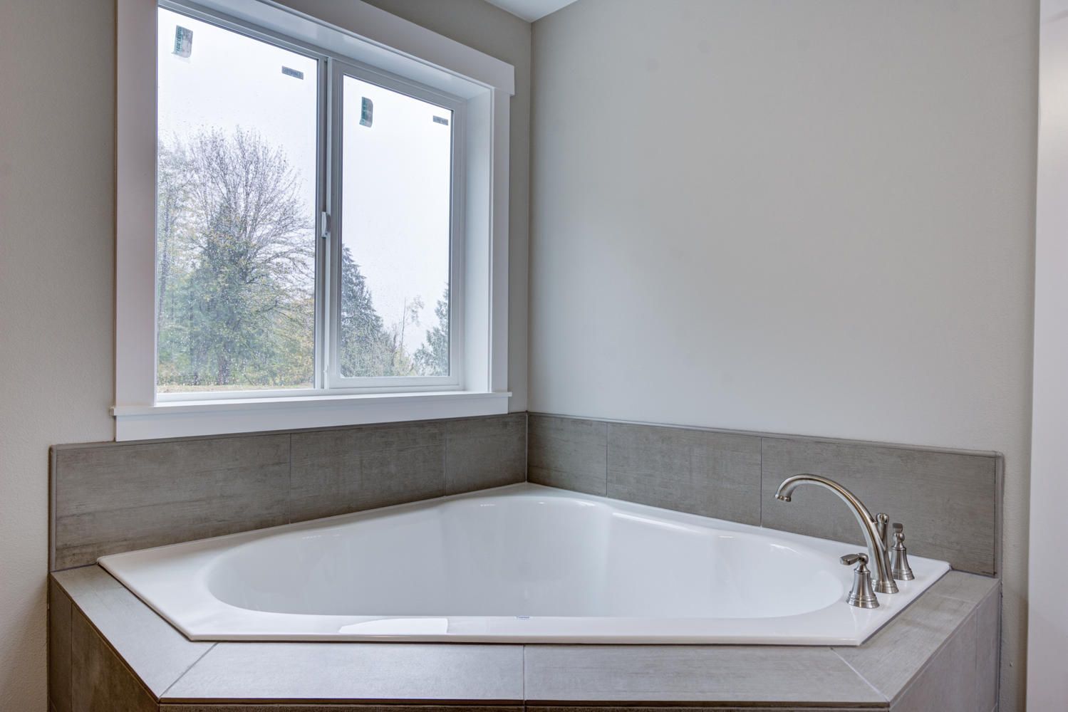 A bathtub in a bathroom next to a window.