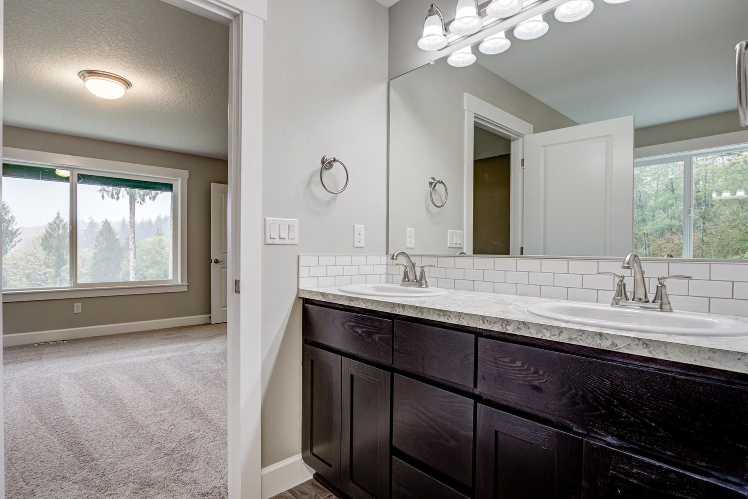 A bathroom with a double sink and a large mirror.