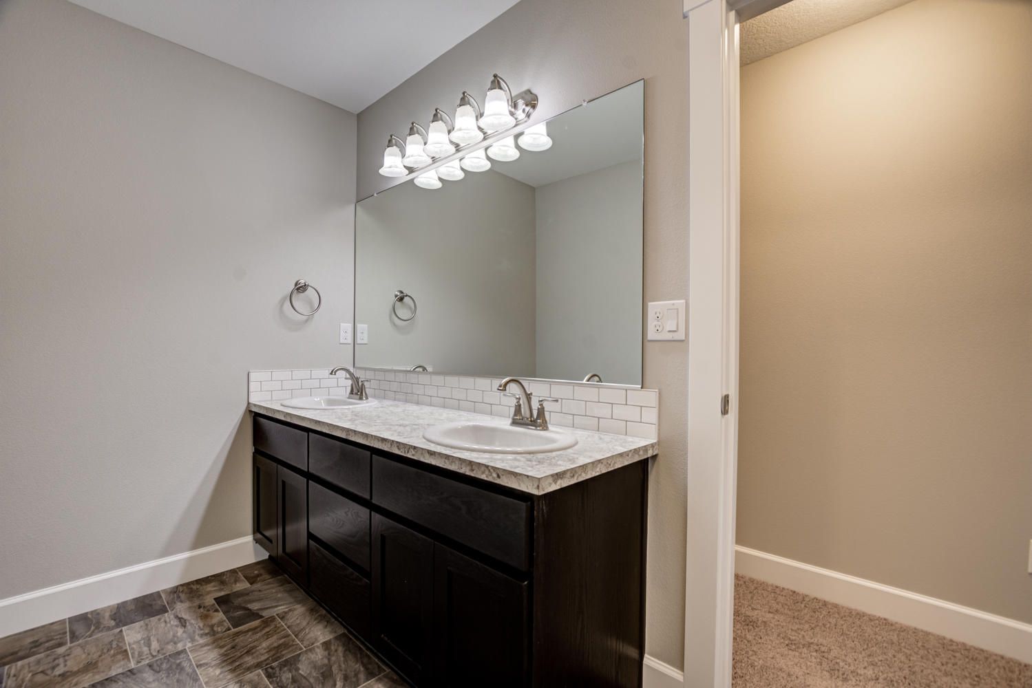 A bathroom with two sinks and a large mirror.