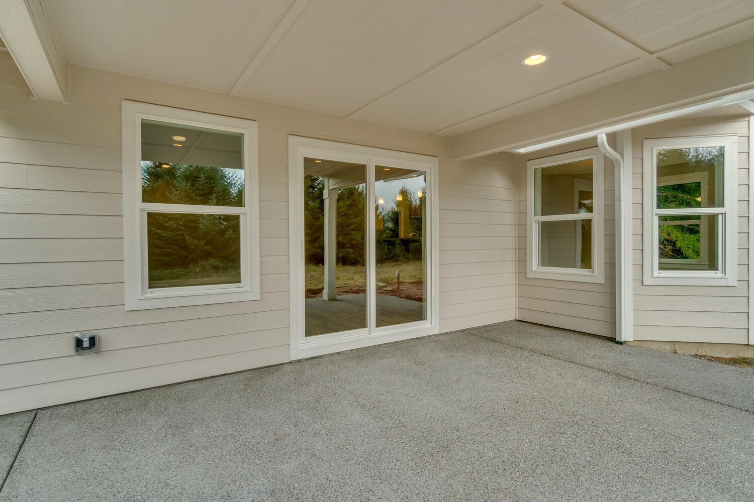 An empty patio with sliding glass doors and windows