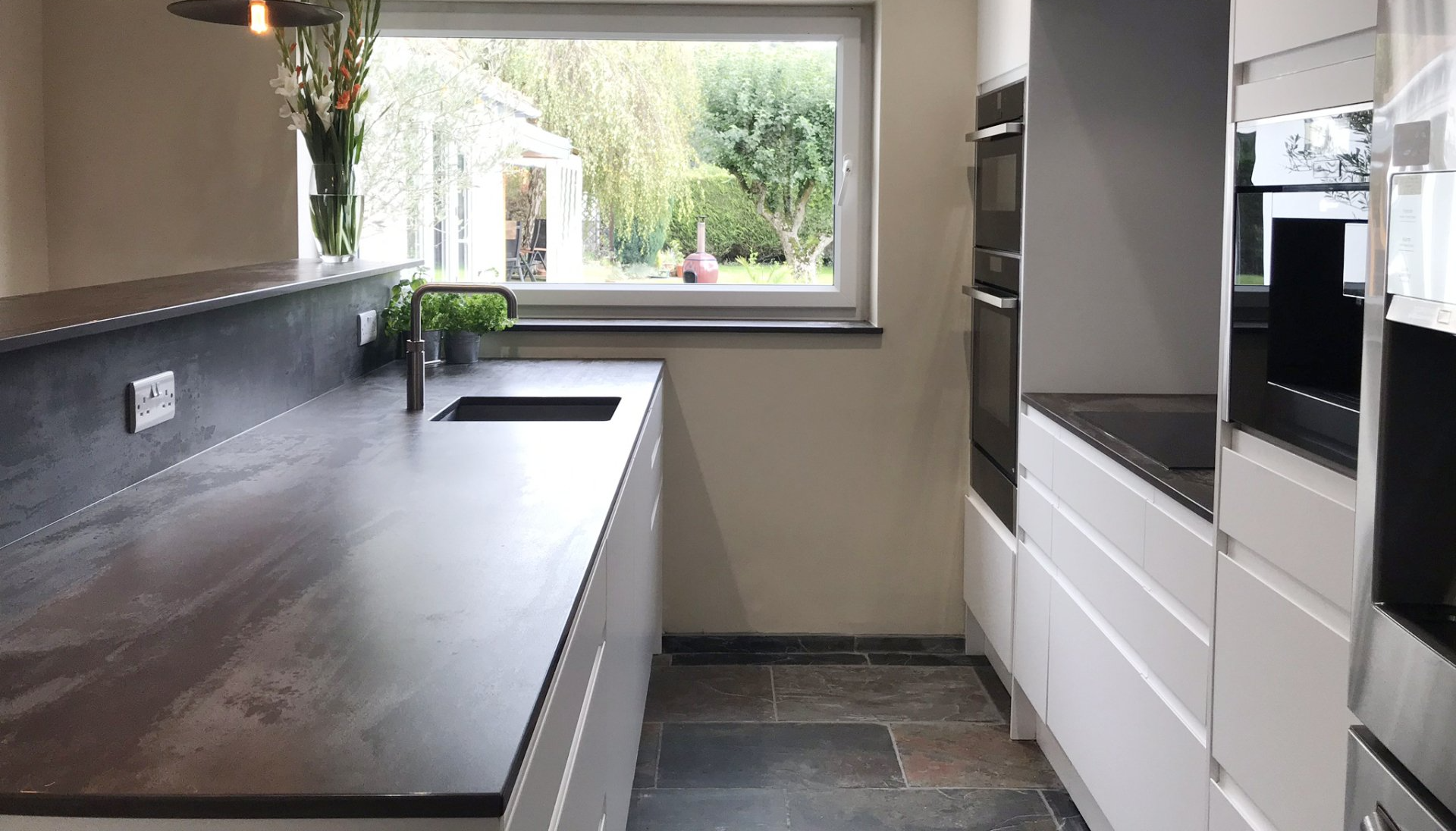 narrow, modern kitchen with charcoal and white theme