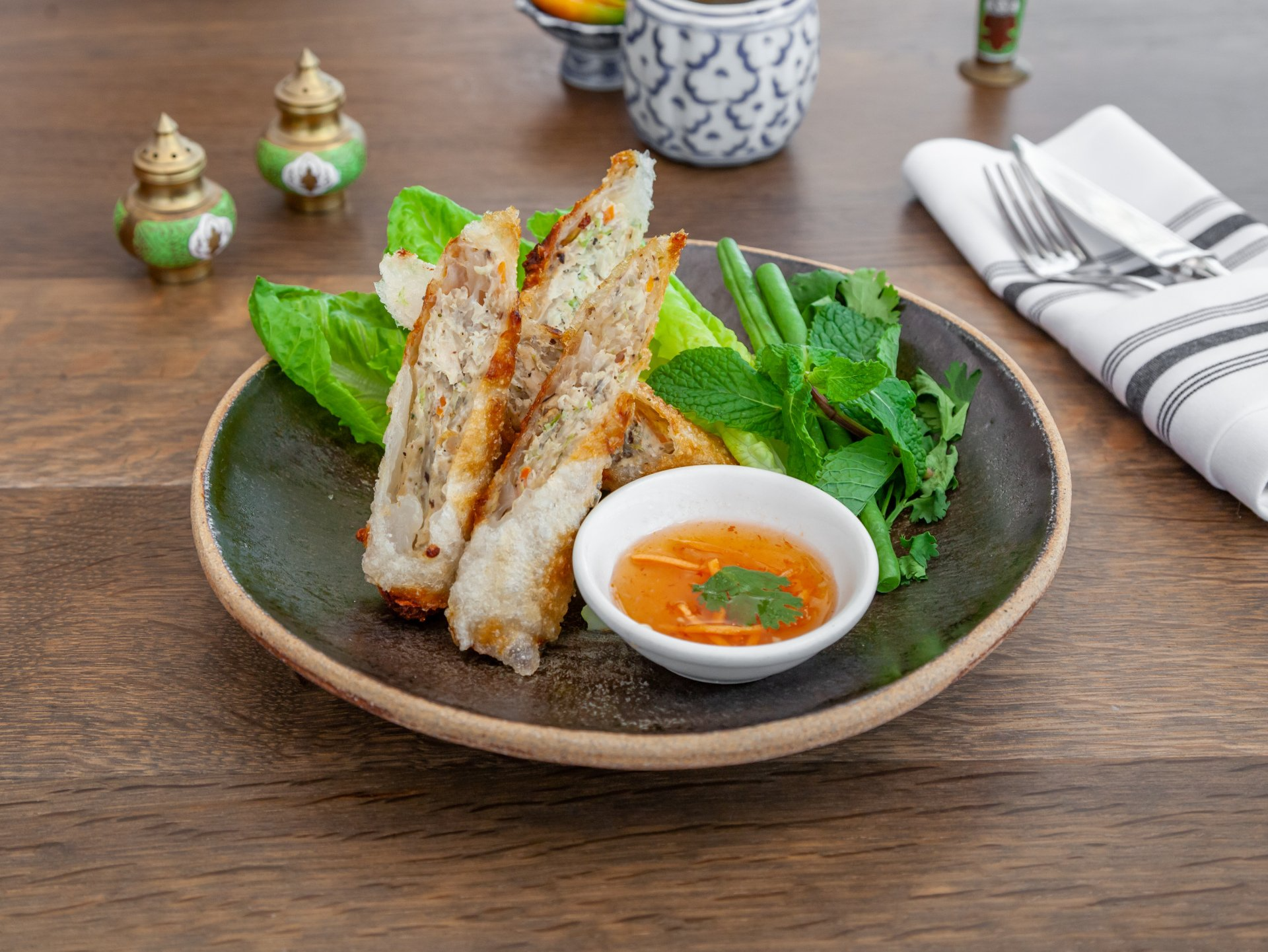 Lao-style fried chicken spring rolls with sweet dipping sauce and peanuts.