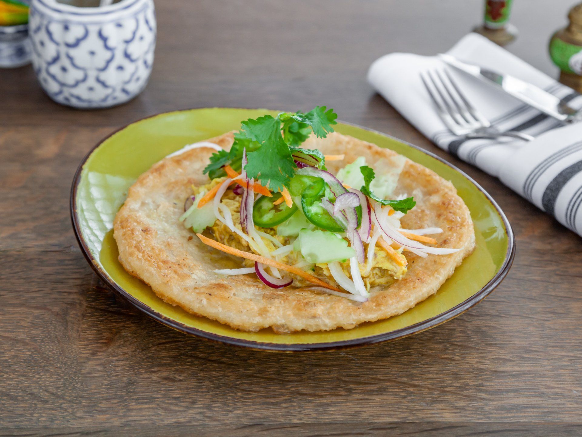 Indian roti flatbread topped with chicken curry and cabbage slaw.