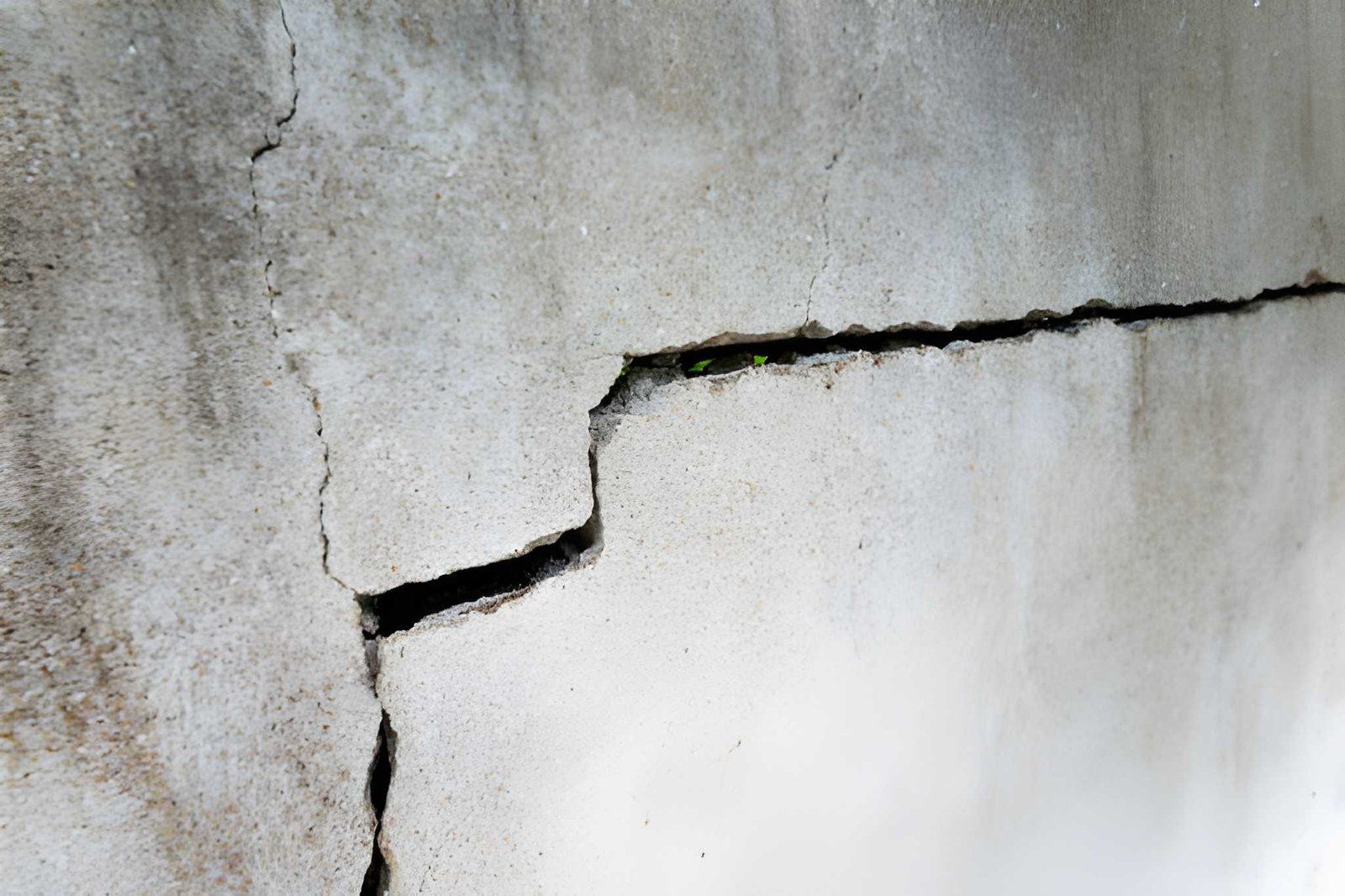 Cracked and peeling plaster wall with a large horizontal fissure