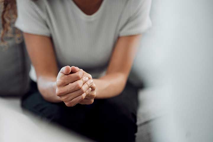 Man sitting with hands clasped