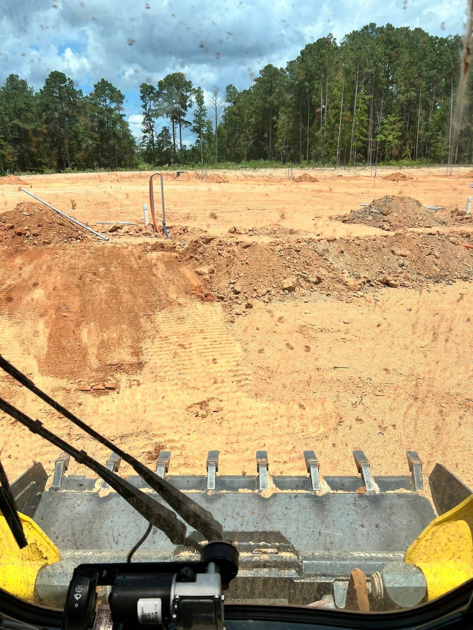 Graded land cleared and prepared for new development with visible utility access points.