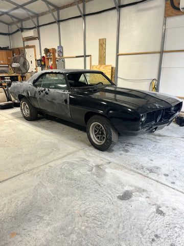 A black car is parked in a garage.