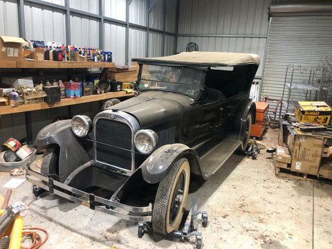 An old car is parked in a garage.