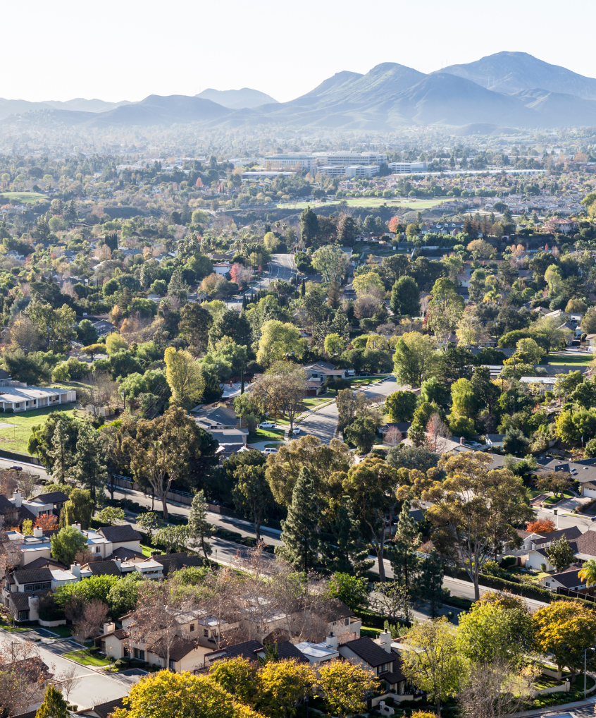 An aerial view of a residential area with mountains in the background.