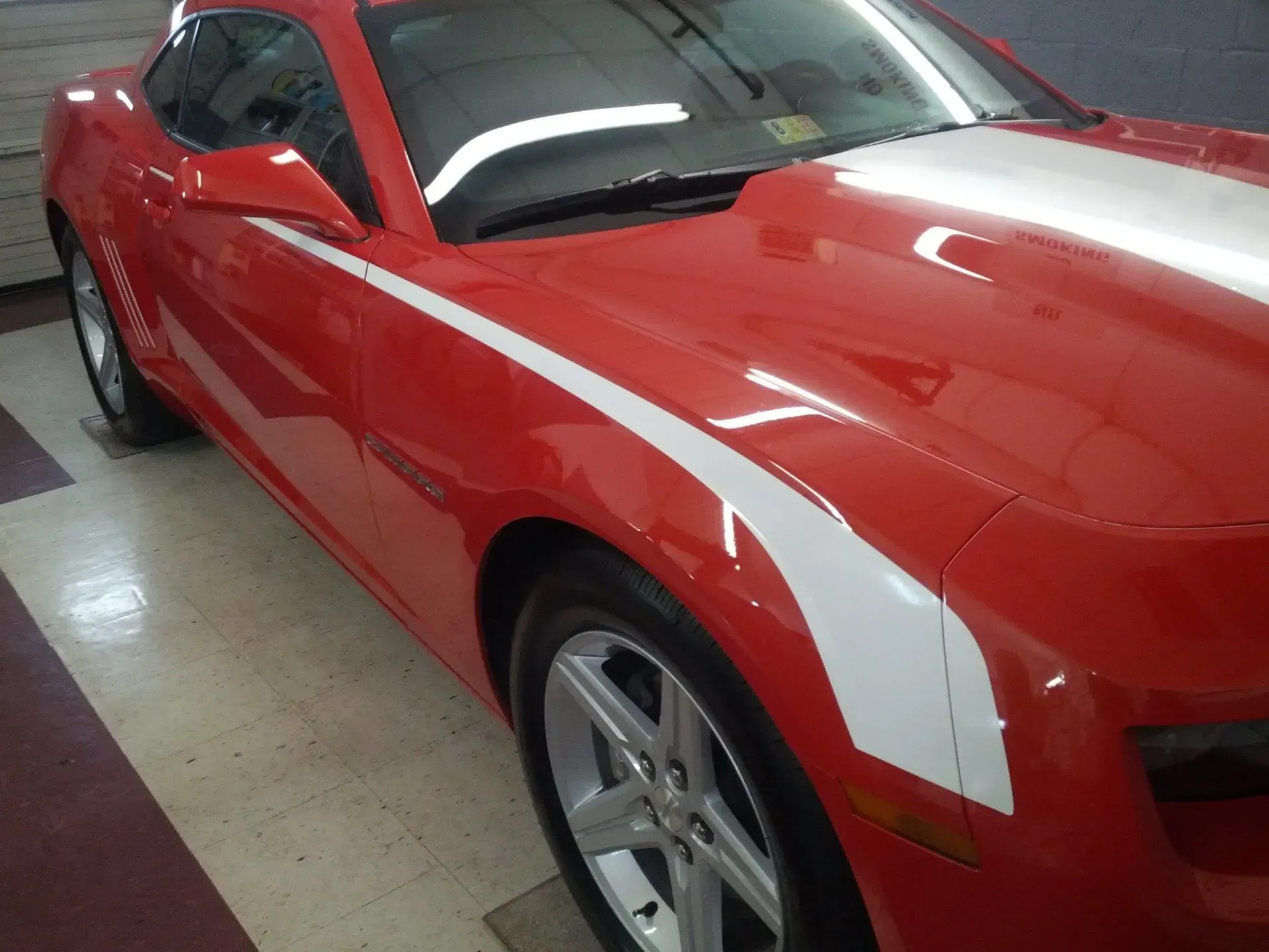 A red car with a white stripe on the side.