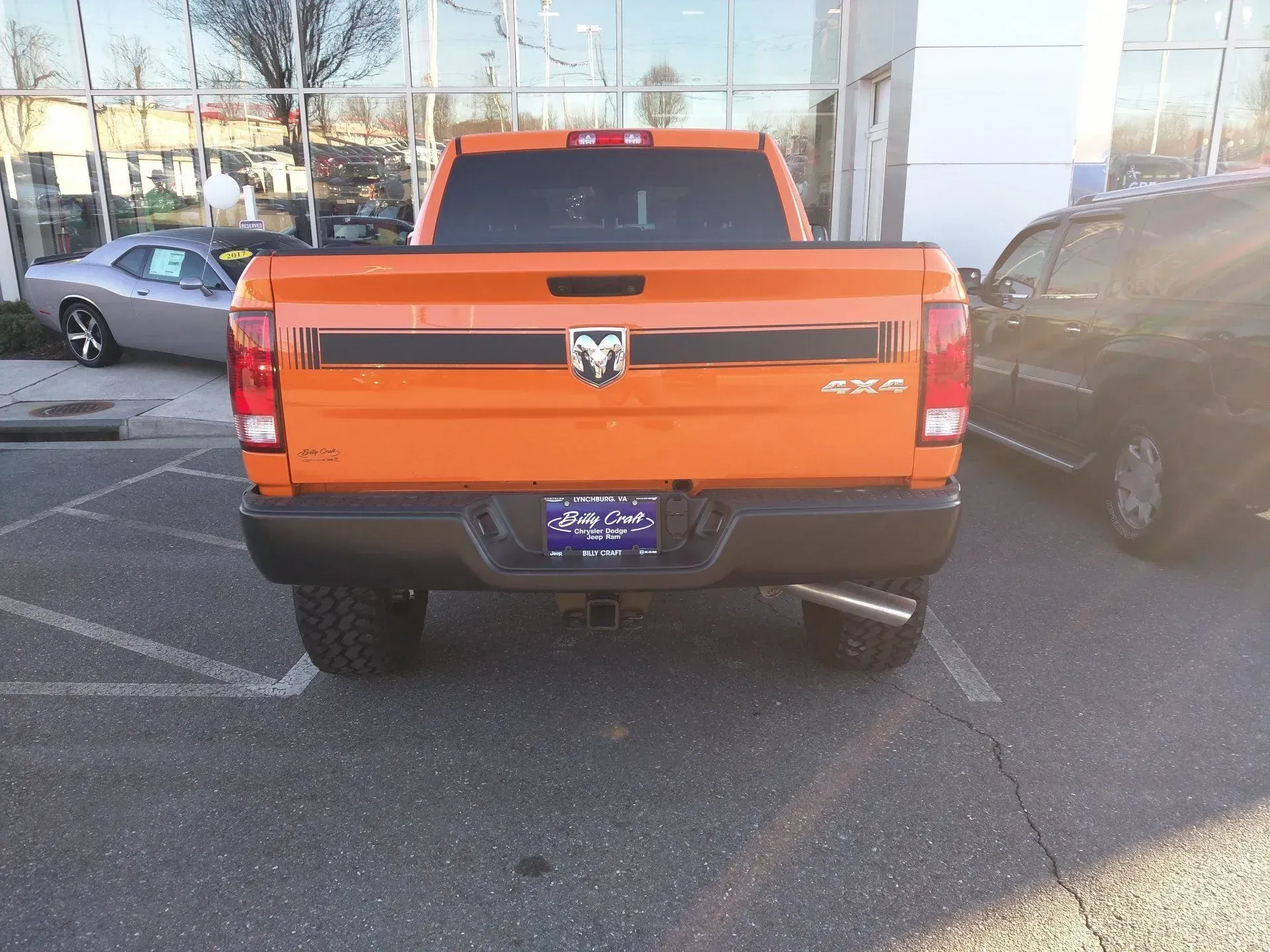 An orange dodge ram truck is parked in a parking lot.