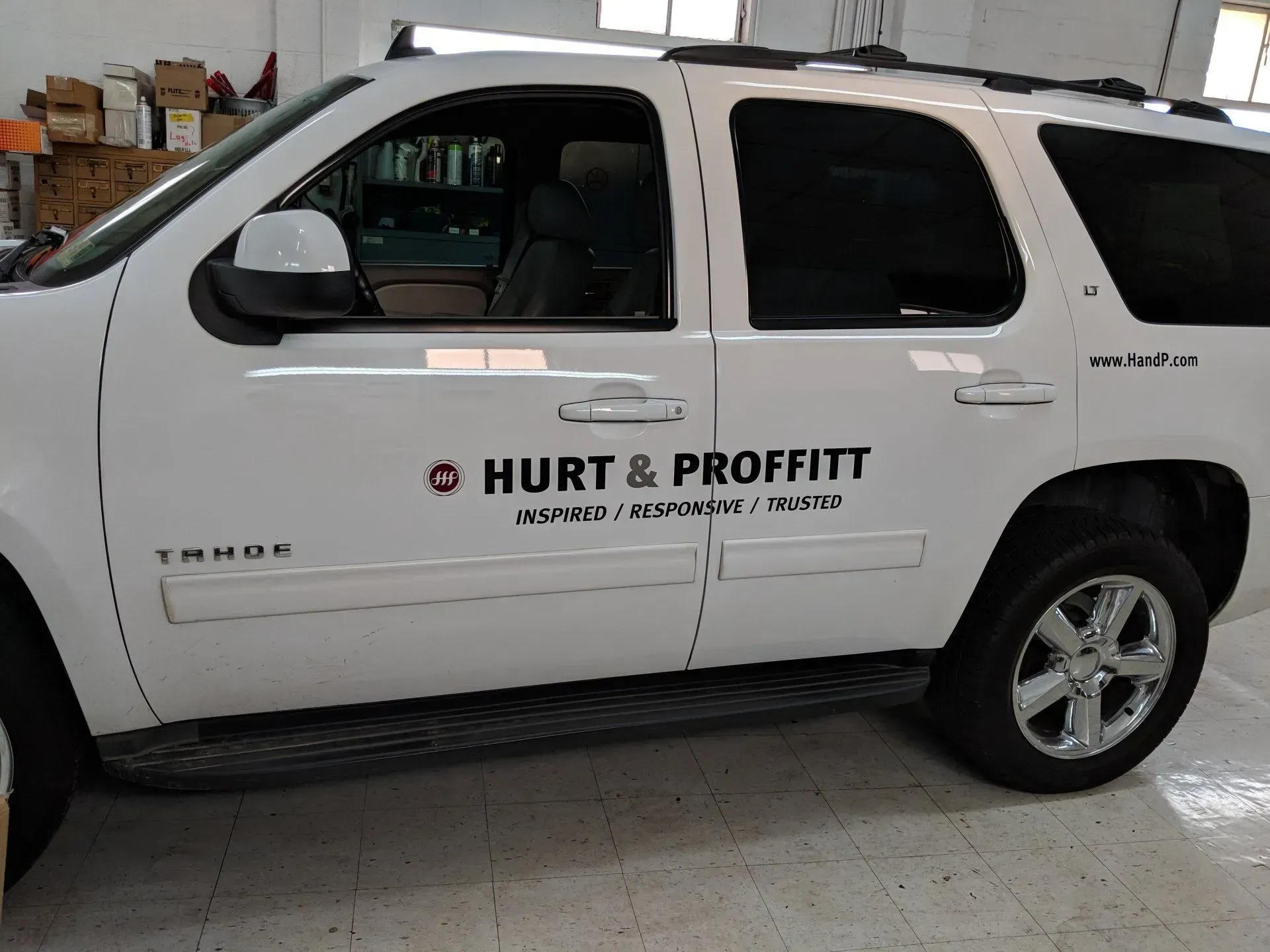 A white SUV with a sticker on the door that says hurt & proffitt.