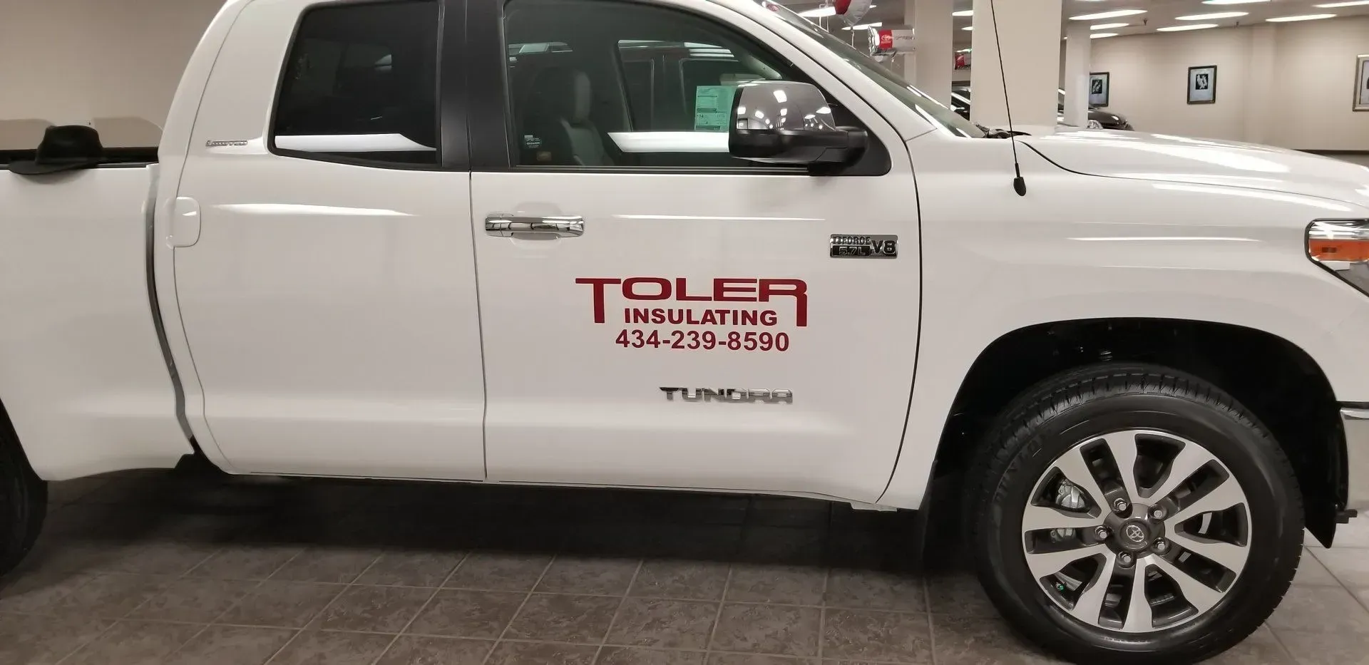 A white truck with the word tolea on the side.