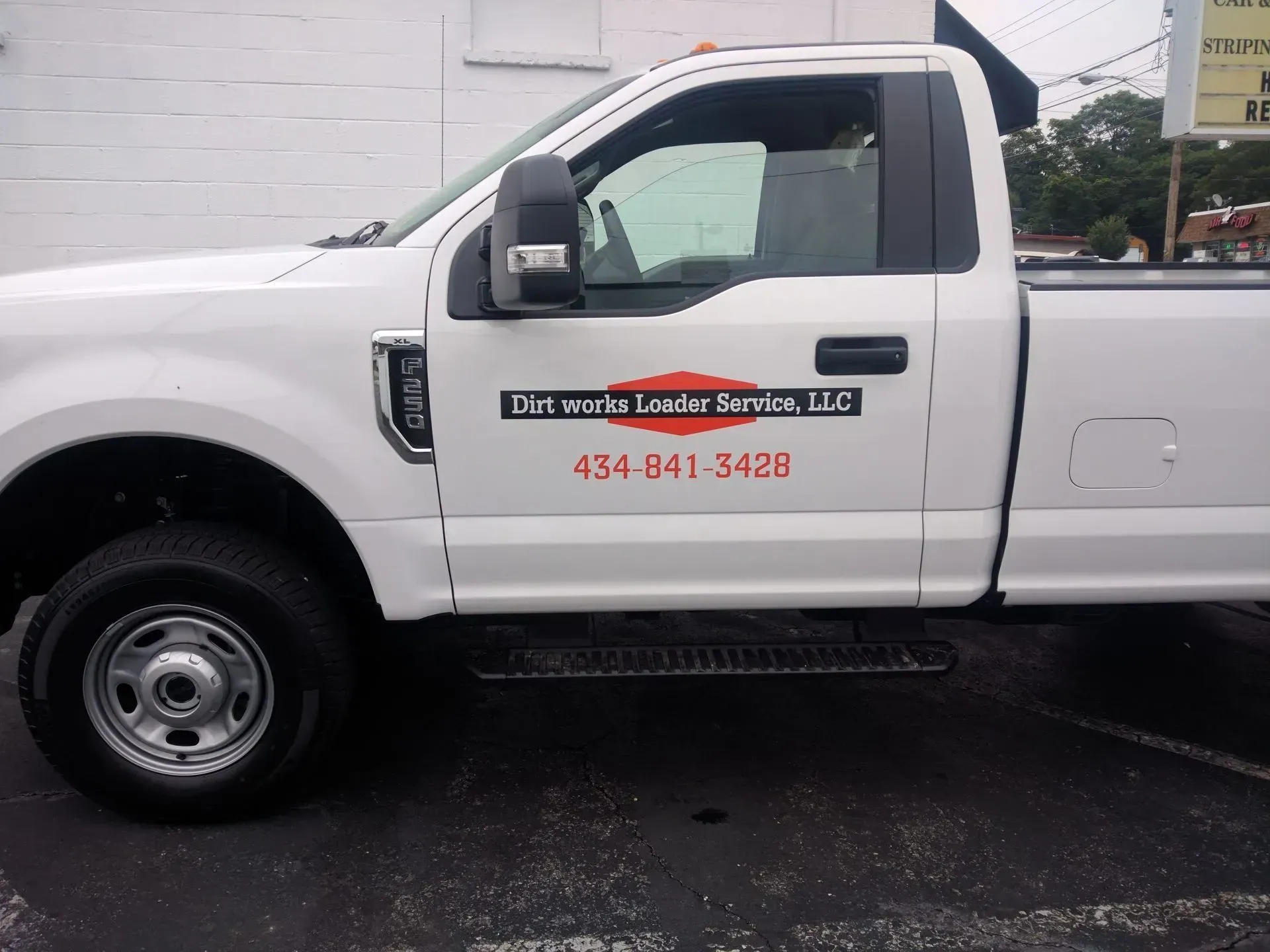 A white truck is parked in front of a building.