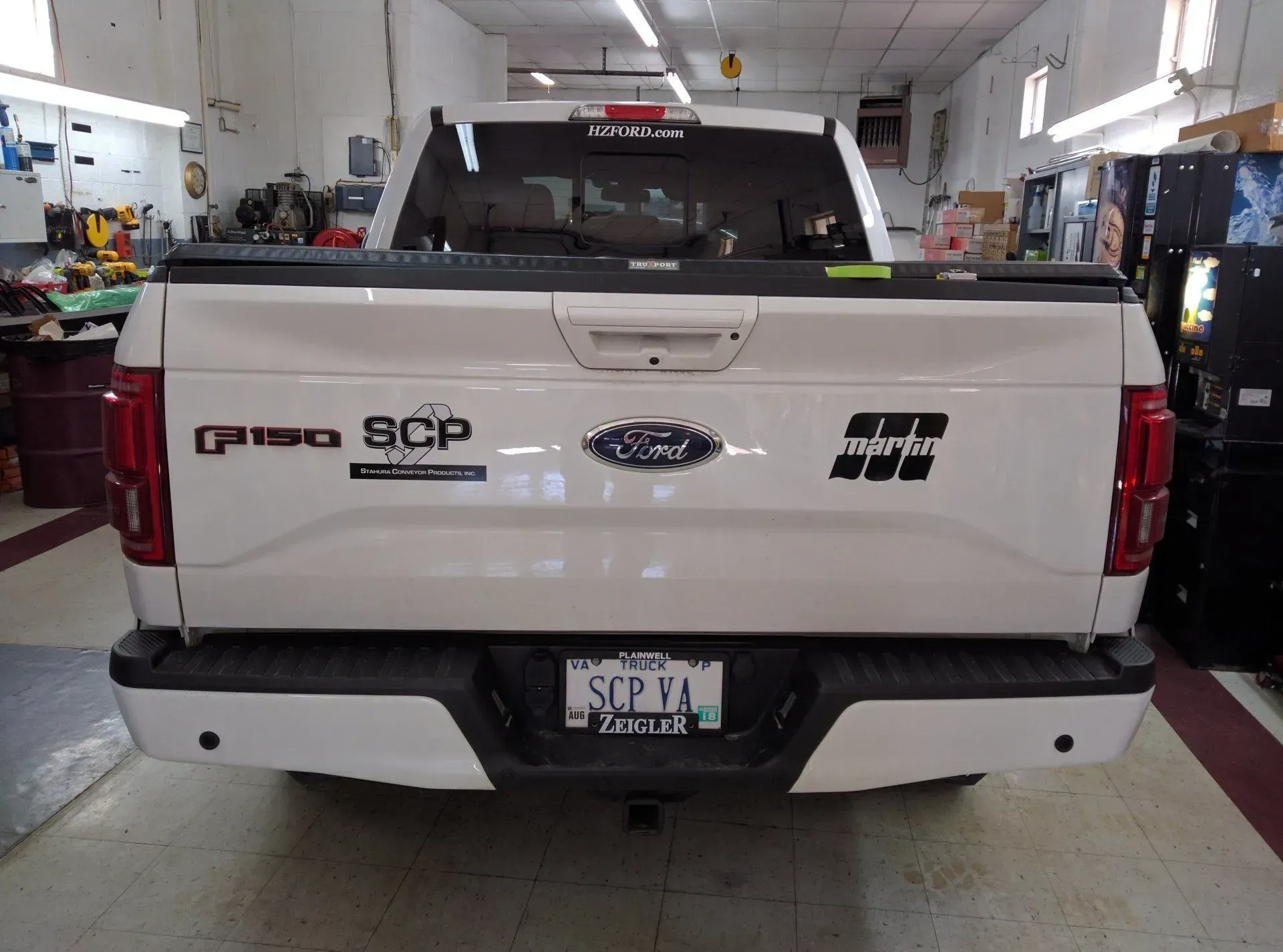 A white ford truck is parked in a garage.