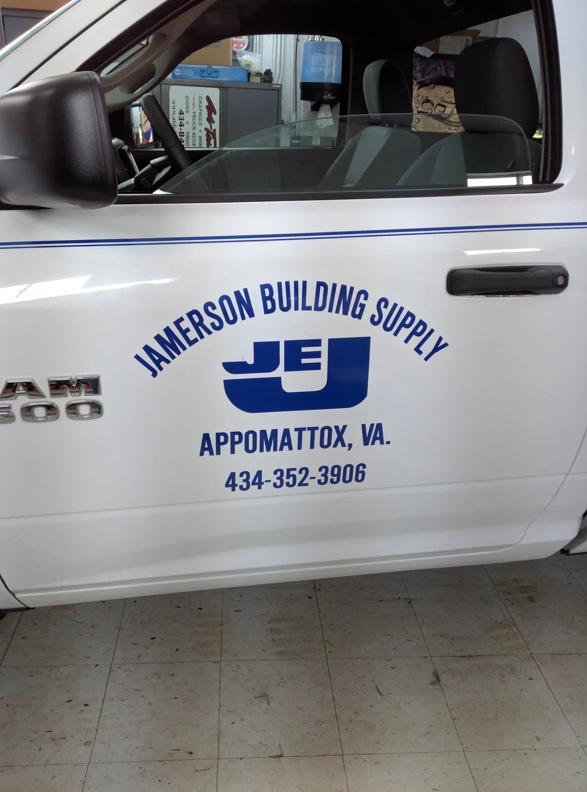 A white truck with the name jamerson building supply on the side.