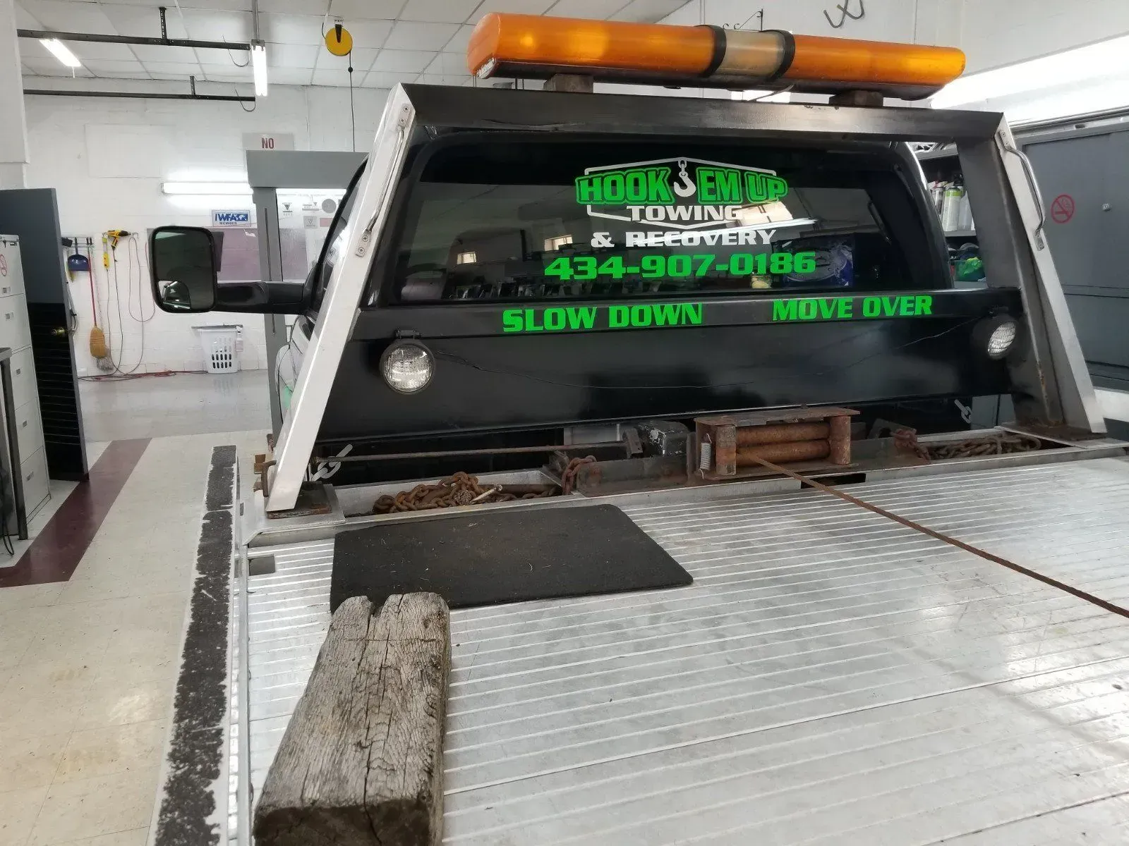 A tow truck is parked in a garage.