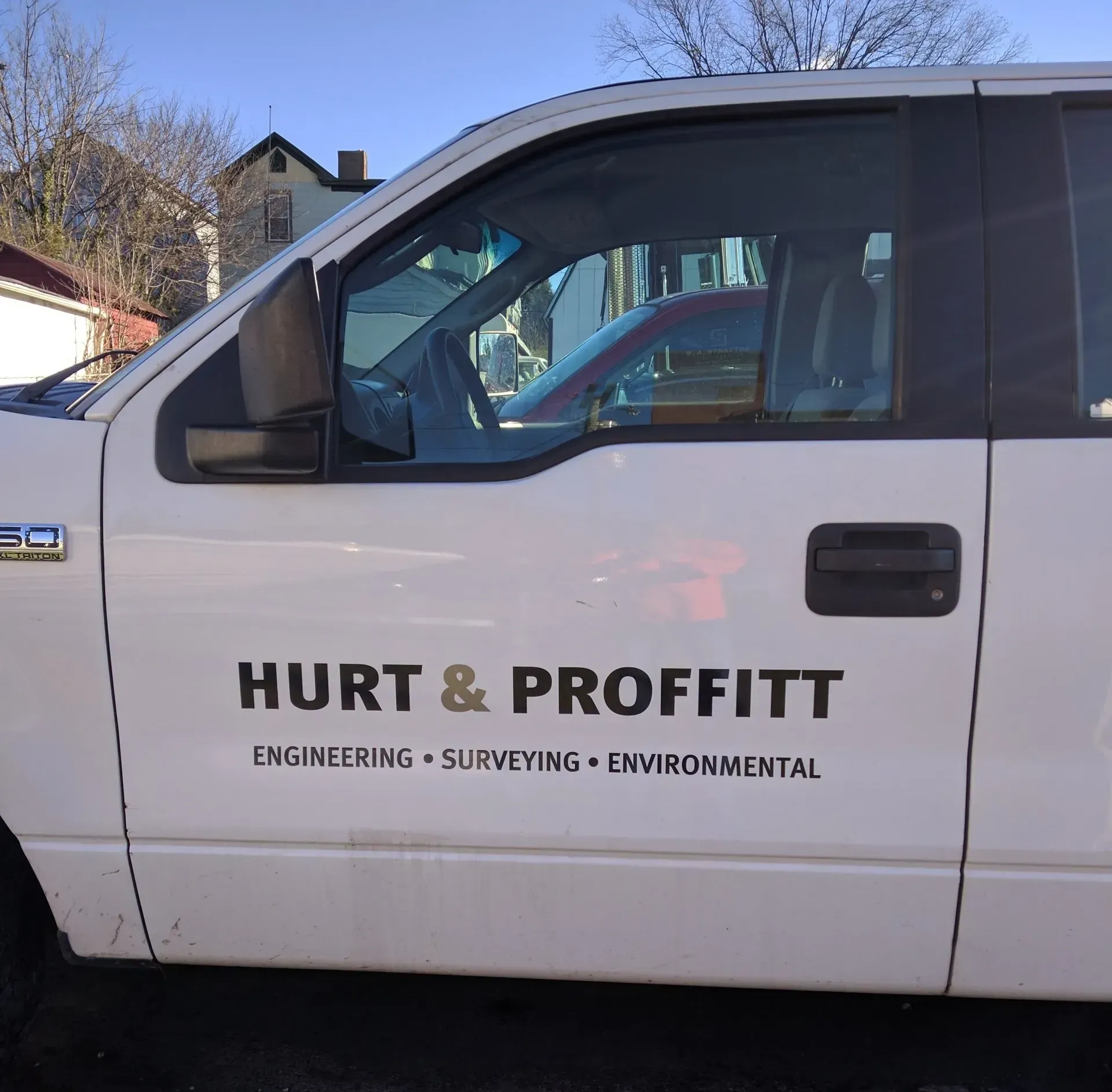 A white truck that says hurt & profitt on the door.