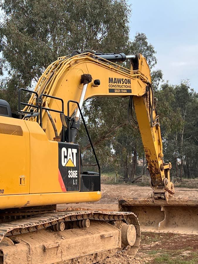 Yellow Excavator on Top of Dirt Field — Mawson Constructions in Kialla, VIC