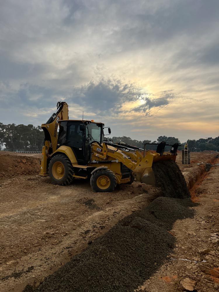A Yellow Bulldozer is Working on a dirt Road — Mawson Constructions in Kialla, VIC