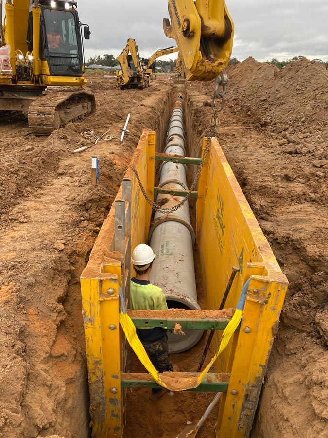 A Man is Working on a Pipe in a Trench — Mawson Constructions in Kialla, VIC