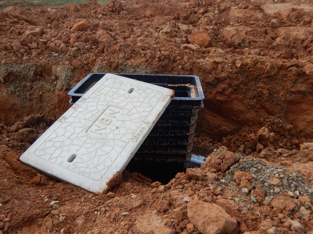 A Manhole Cover is Sitting in a pile of dirt — Mawson Constructions in Kialla, VIC