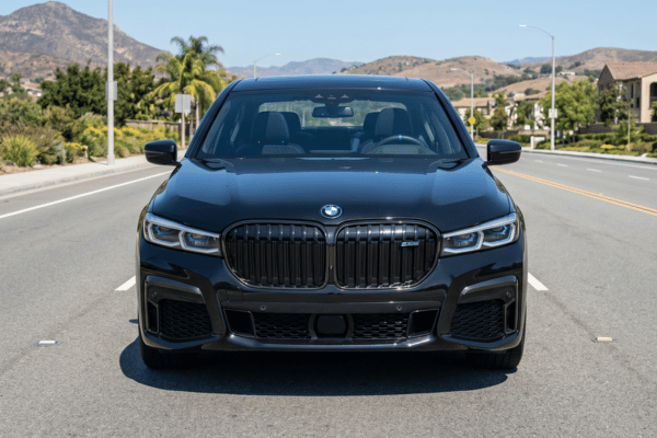Black BMW sedan driving on suburban road