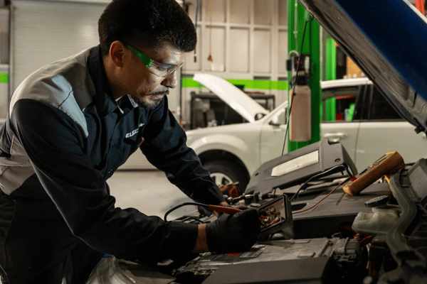 Electron Automotive technician testing car battery with diagnostic tool
