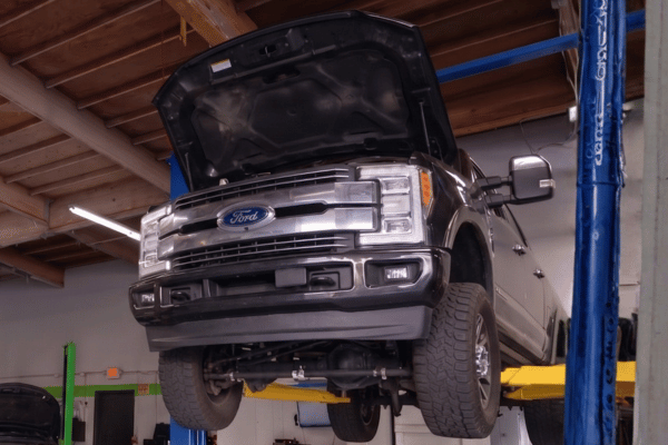 Pickup truck raised on lift in repair shop