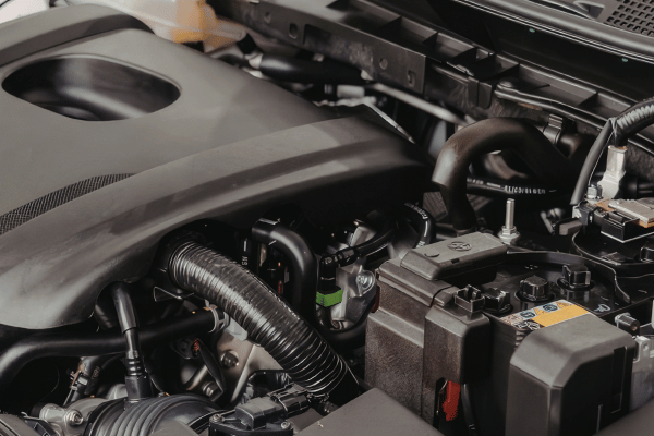 Car engine bay with components and battery