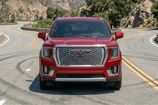 Red GMC truck driving on mountain road