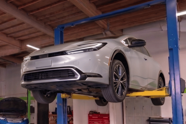 Hybrid vehicle raised on lift in service bay