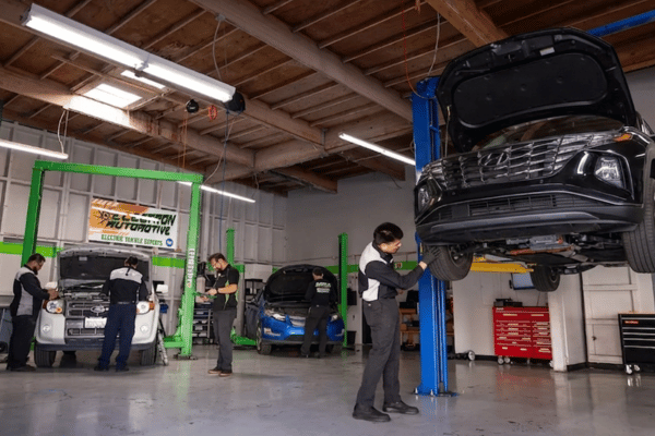 Electron Automotive shop with technician inspecting black Hyundai on lift