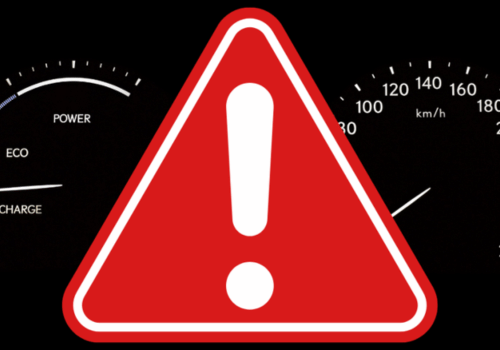 Red warning triangle with an exclamation mark displayed over a vehicle dashboard and instrument cluster background.