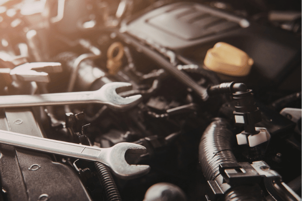 Wrenches resting on car engine components during maintenance