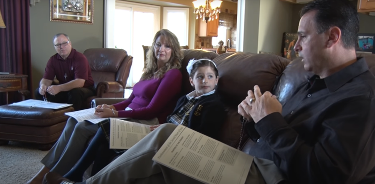 A family is sitting on a couch in a living room