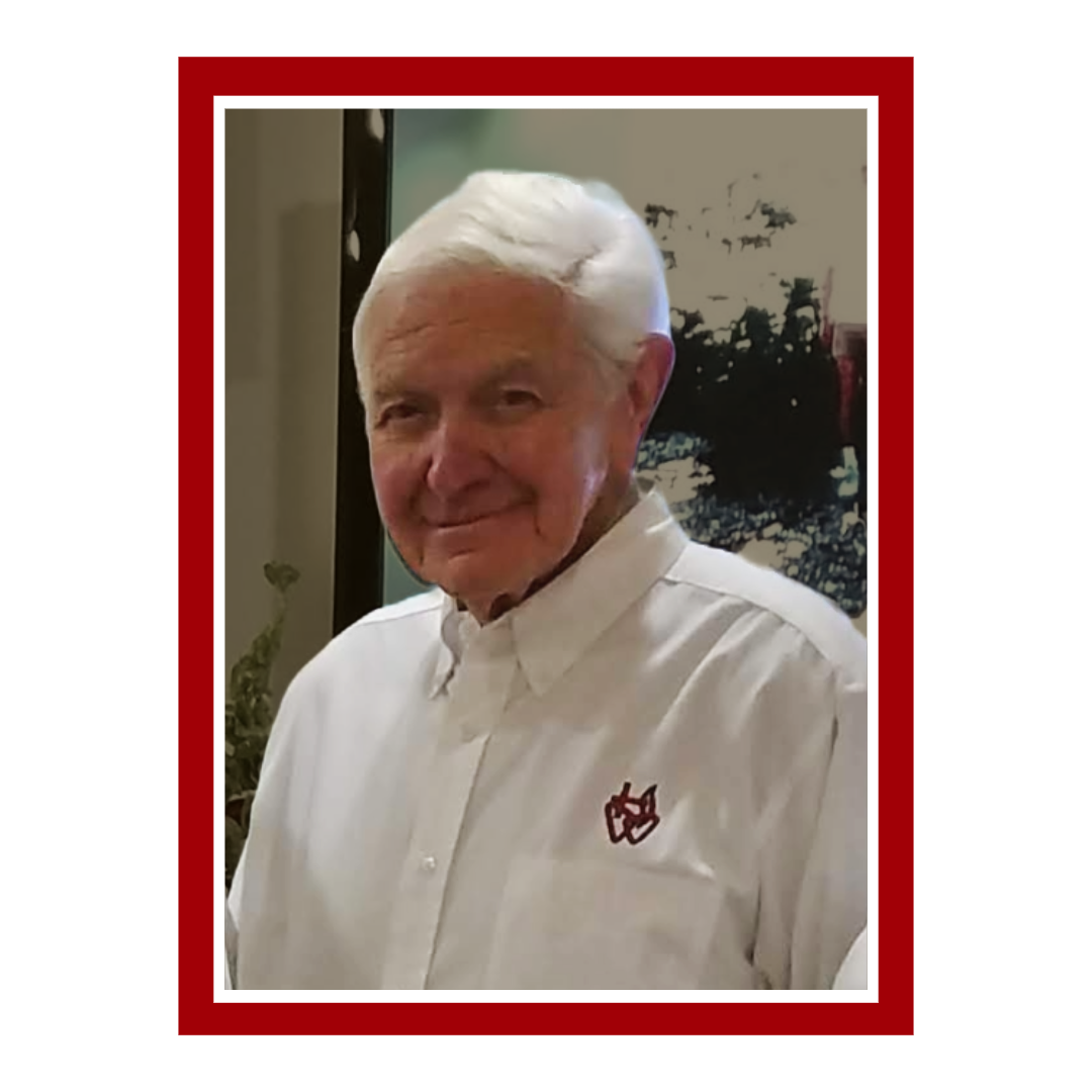 A man wearing a white shirt with a red logo on the sleeve